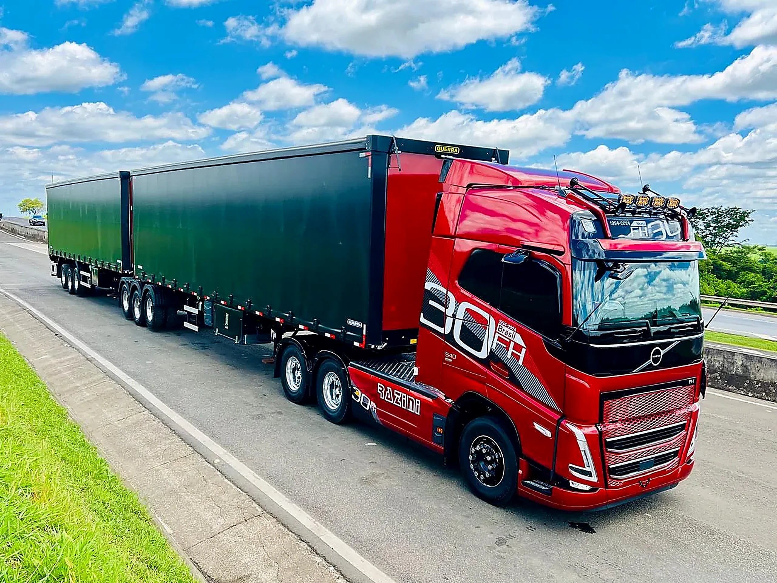 Rodotrem vermelho da Razini, Volvo FH 540 Edição 30 Anos, com dois semirreboques em rodovia