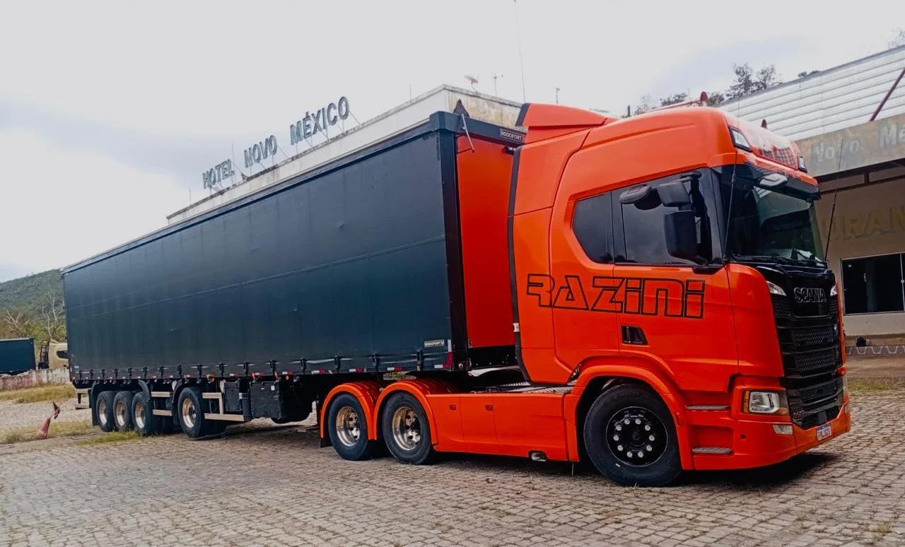 Scania laranja da Razini engatado a semirreboque de lona lateral